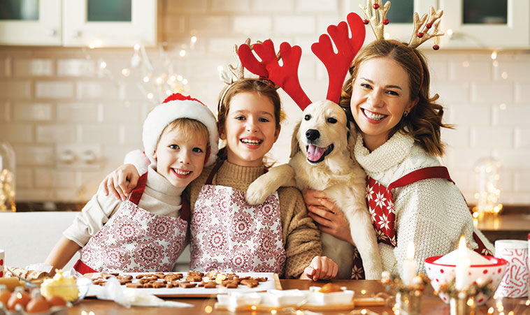 Aspettando il Natale  nella foto mamma con le figlie e il cane che preparano i biscotti anche per lui