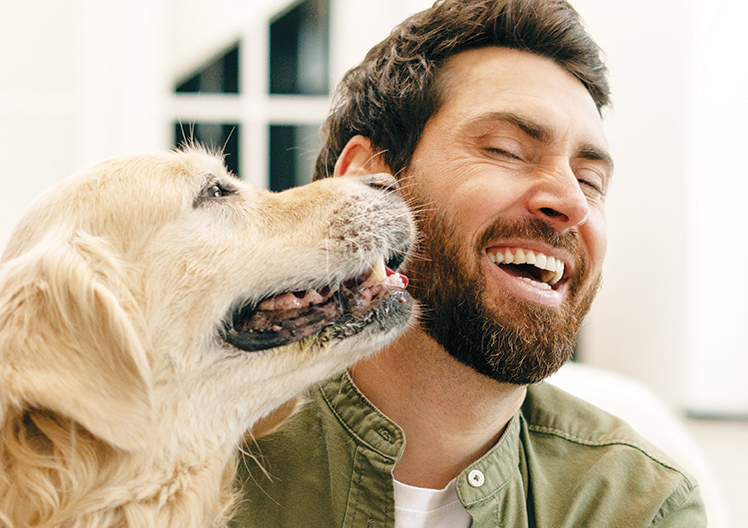 il cane con il suo proprietario che si coccolano a vicenda in un appartamento